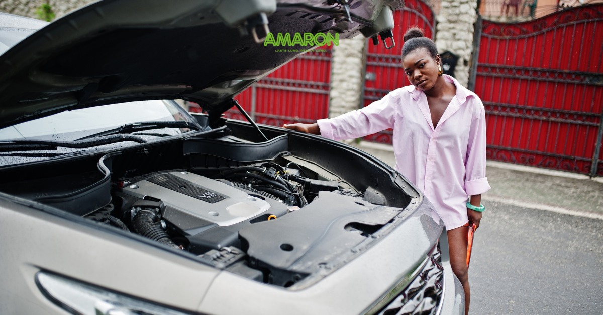 Woman looking over an open car bonet bay